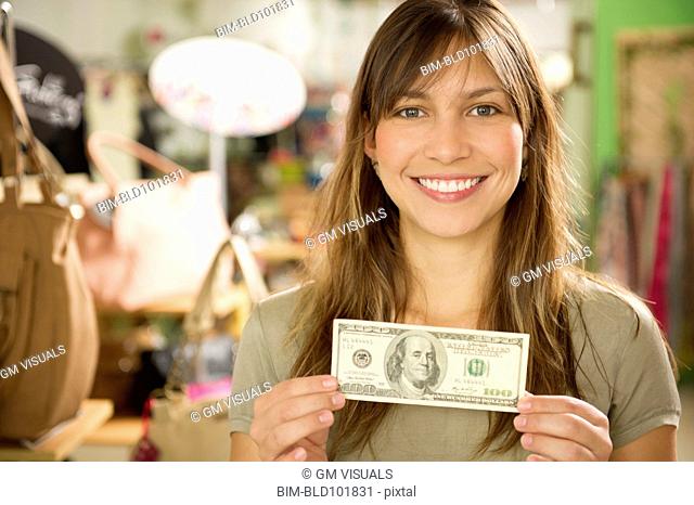 Hispanic woman holding cash in store