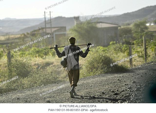 29 January 2019, Ethiopia, Lalibela: A man walks along a dusty country road. Photo: Britta Pedersen/dpa-Zentralbild/ZB. - Lalibela/Rampart/Ethiopia