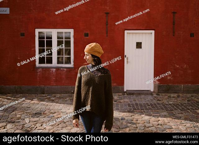 Woman standing on cobblestone street in front of building