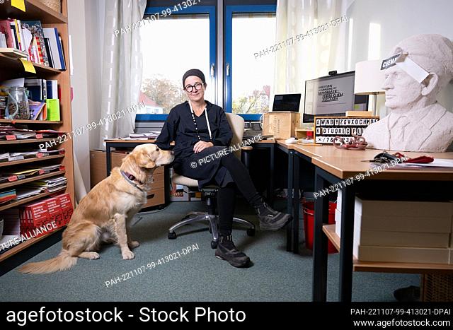 PRODUCTION - 24 October 2022, Saxony, Dresden: Anja Besand, an educationalist, sits in her office at the TU Dresden next to her golden retriever Sidan