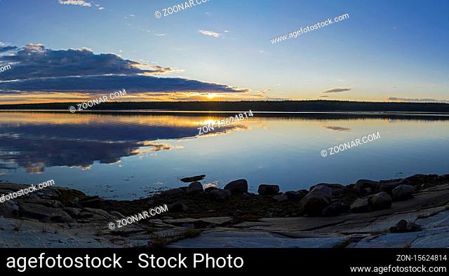 Evening on the White Sea. The sun shines through the clouds. Kandalaksha Gulf, Karelia, Russia, end of June