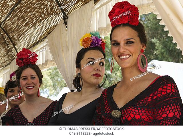 Women wearing beautifully coloured gypsy dresses during the annual Pentecost pilgrimage of El Rocio. Huelva province, Andalusia, Spain