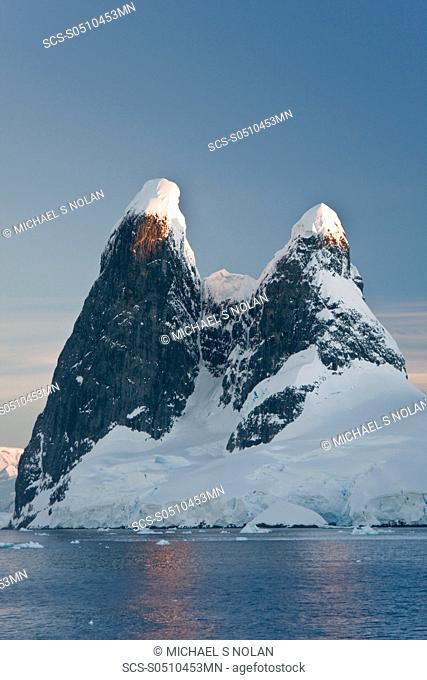 The Lindblad Expedition ship National Geographic Explorer transits Lemaire Channel in late evening light on the west side of the Antarctic peninsula in...