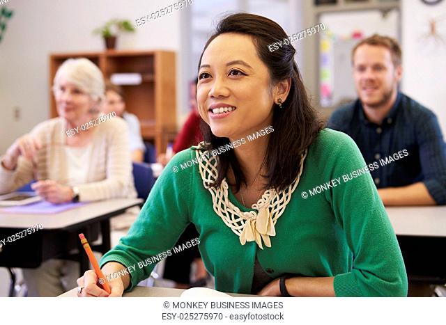 Asian woman looking at the board in an adult education class
