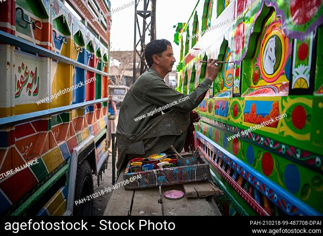 14 February 2021, Pakistan, Rawalpindi: Painter Mohammed Said paints a truck in a backyard near the Pakistani capital. (to dpa: ""Master painter Asad Khan and...