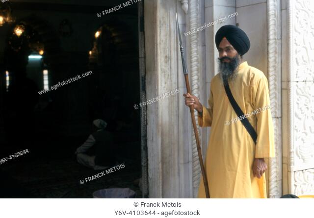 A sikh man is guarding the entrance of a ""gurudwara"" ( sikh place of worship) ( Delhi, India)