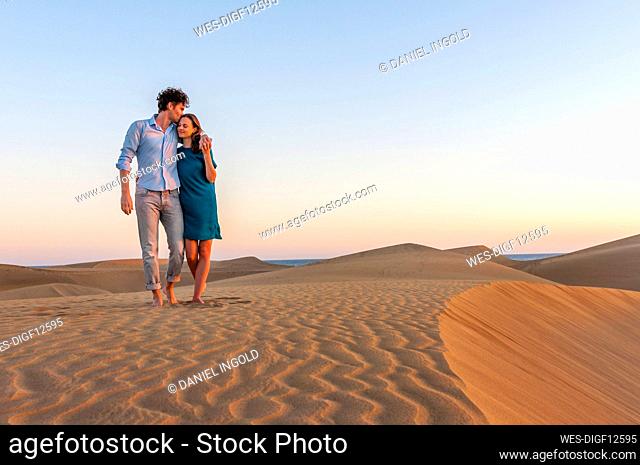 Affectionate couple walking in the dunes at sunset, Gran Canaria, Spain