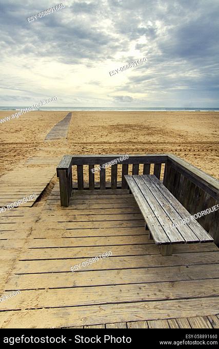 View of wooden passage in a long empty beach shoreline