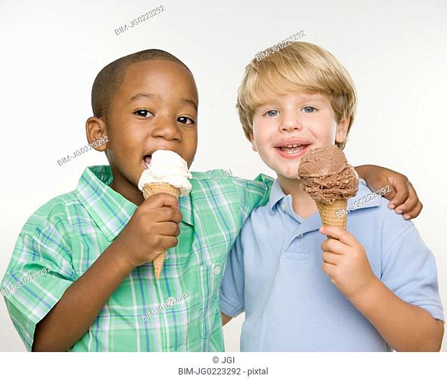 Two young boys eating ice cream cones
