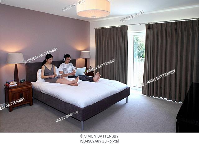 Couple surfing the internet in bedroom
