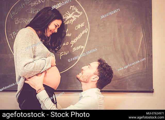 nice caucasian couple at home touching the belly and waiting for the new baby coming. pregnant concept for new mother and father