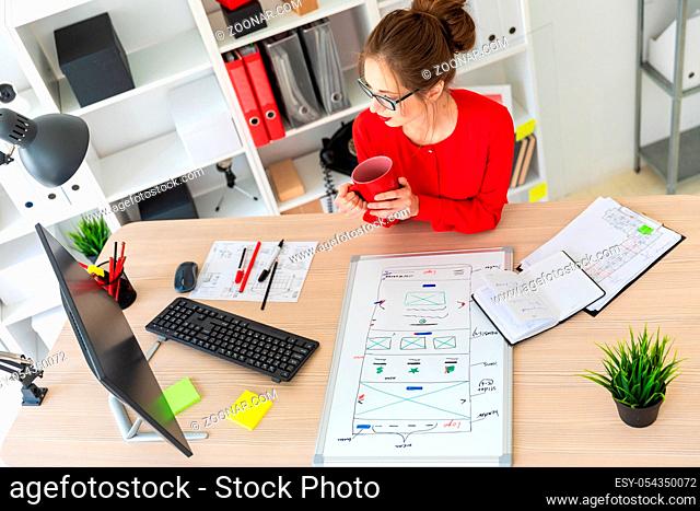 Beautiful young girl in glasses and a red shirt is working in the office. photo with depth of field