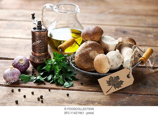 An arrangement of porcini mushrooms, oil, parsley, garlic and pepper