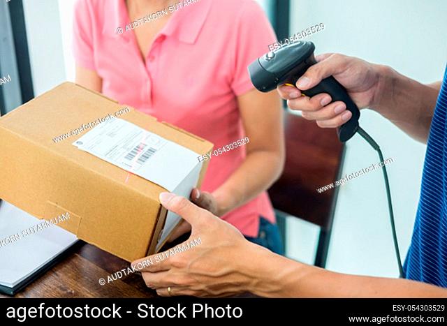 Courier hands Business woman work at home office checking parcel package box by keying machine track tools before ship and documents data