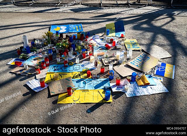 Berlin, Germany, Europe - An improvised memorial made of signs, paintings, candles and flowers for the victims of the war in the Ukraine is seen on the ground...