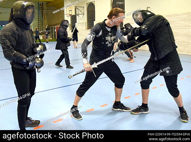 08 September 2022, Saxony, Leipzig: Historical fencing with long swords is practiced in a gymnasium by fencing instructor Torsten Schneyer (2nd from right) with...