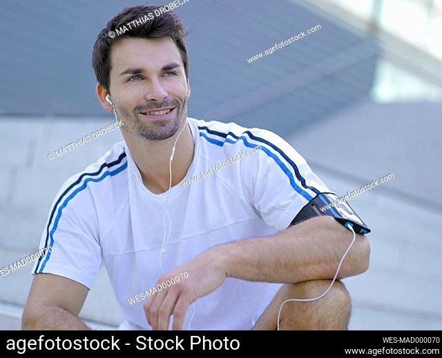 Portrait of smiling jogger with earphones