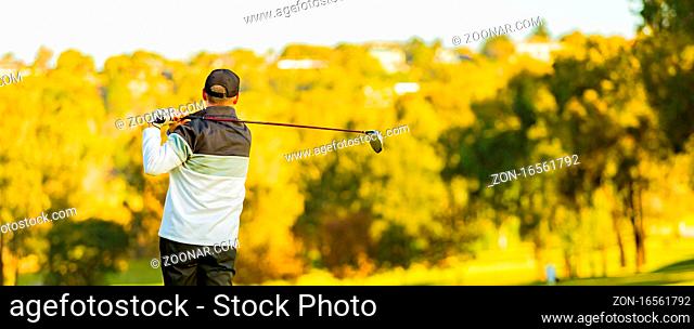 Man teeing off on a golf course Tee with a driver club