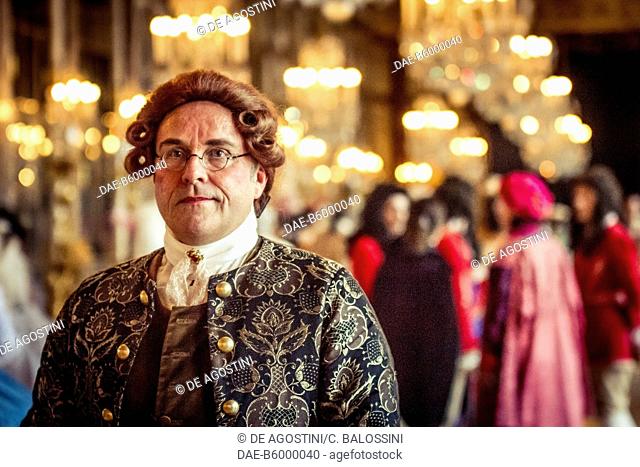 A man wearing a wig and glasses in the Hall of Mirrors, courtship party (Fete galante) with participants wearing clothes from the Louis XIV period