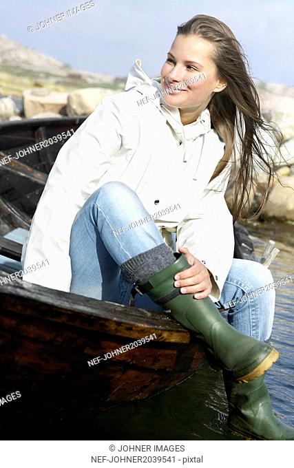 Smiling woman siting in wooden boat