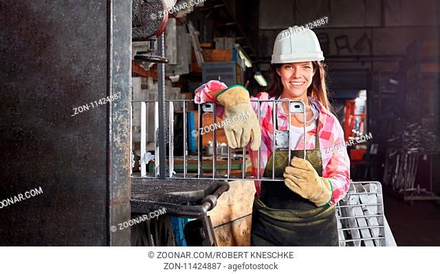 Junge Frau als Arbeiterin in einer Metallfabrik an Gußformen