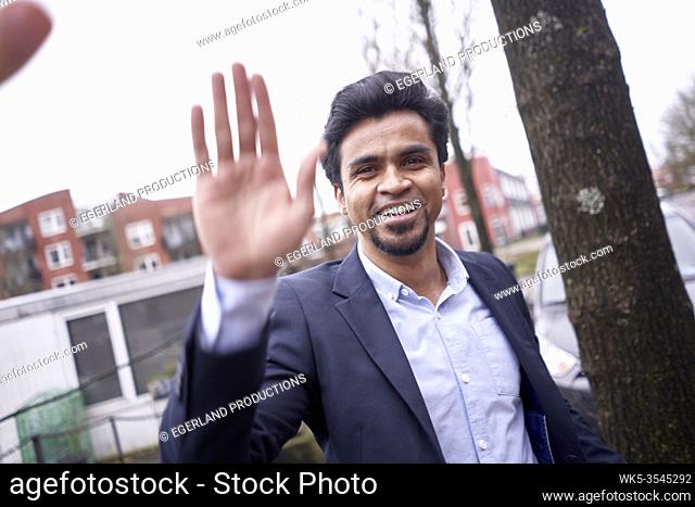 Indian businessman giving high five in Leeuwarden, Friesland, Netherlands, Europe