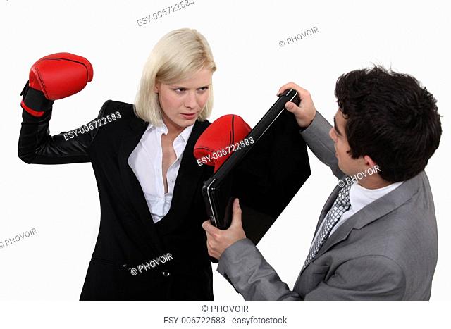 Woman with boxing gloves attacking colleague