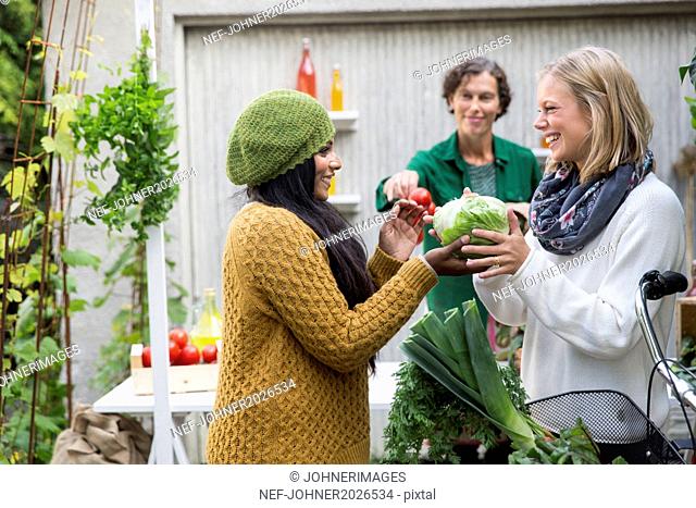 Young women looking at home-grown vegetables