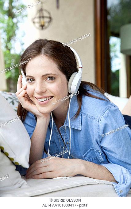 Young woman listening to headphones, portrait