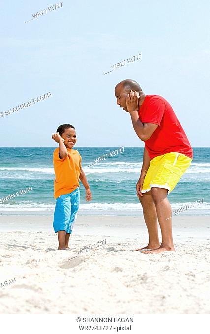 Father and son holding shells