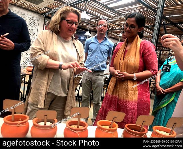 09 June 2023, India, Neu Delhi: Development Minister Svenja Schulze (SPD, l) is shown different types of millet during her visit to India in the Indian capital...