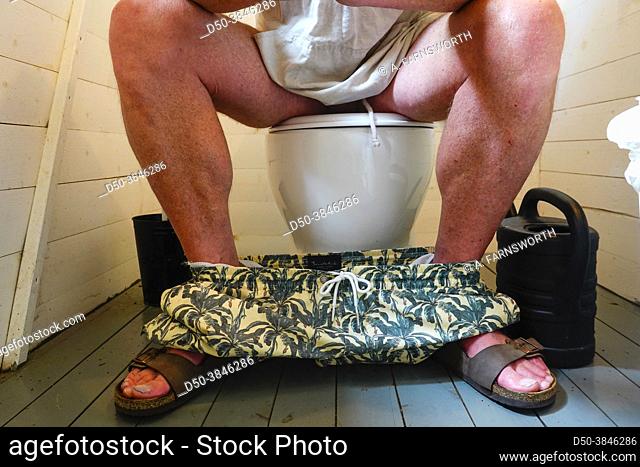 A man sits on the toilet