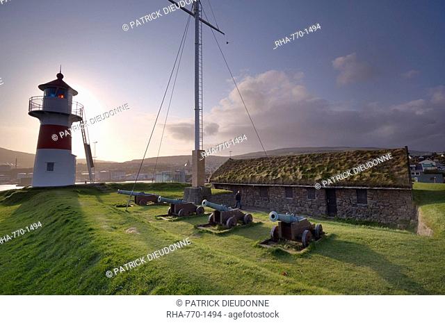 Skansin fort, old fort guarding Torshavn and its harbour old brass cannons, WW2 british marine guns and lighthouse, Nolsoy in the distance, Torshavn, Streymoy