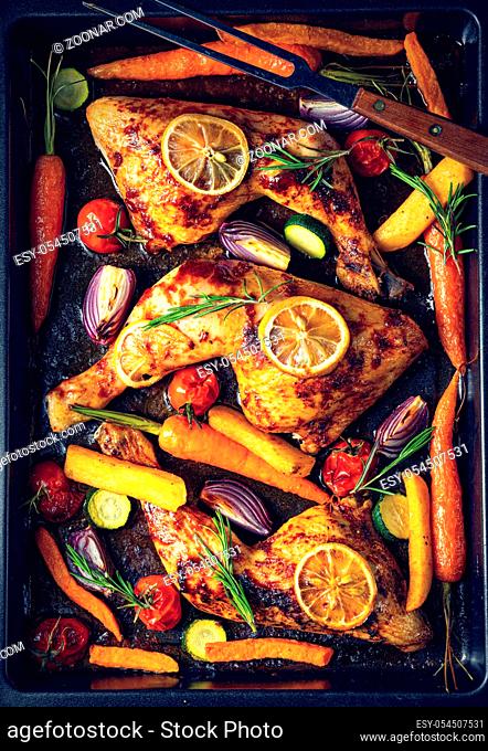 Grilled chicken legs with various vegetables and herbs