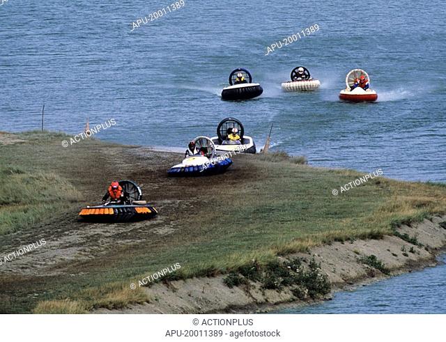 Hovercrafts racing across the ground and lake