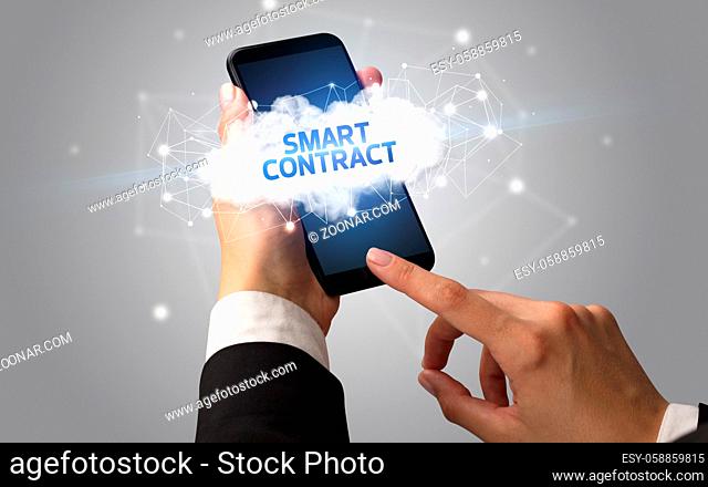 Female hand touching smartphone with SMART CONTRACT inscription, cloud business concept