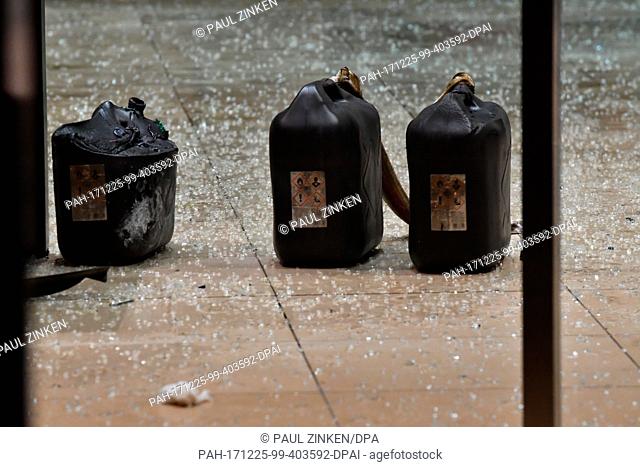 Three petrol cannisters on the ground, which is covered with shards, at SPD party headquarters in Berlin, Germany, 25 December 2017