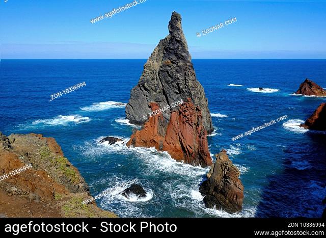 Zwei steile, vulkanische Klippen in roetlichem und grauem vulkanischen Gestein sind der Insel vogelagert und stehen wellenumtost im Atlantik