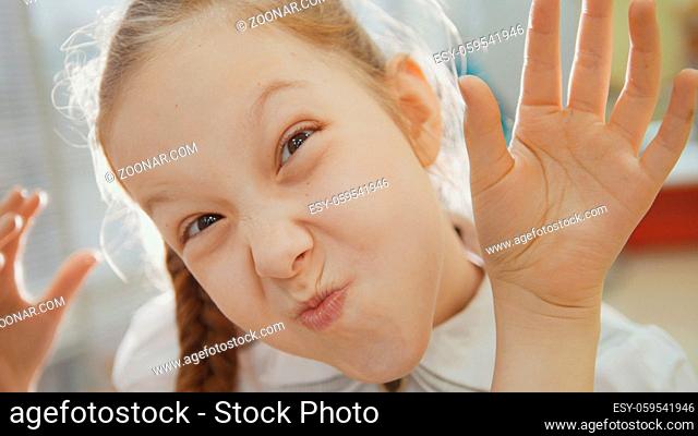 Little girl have funny and shows into camera piglet nose and tongue, close-up