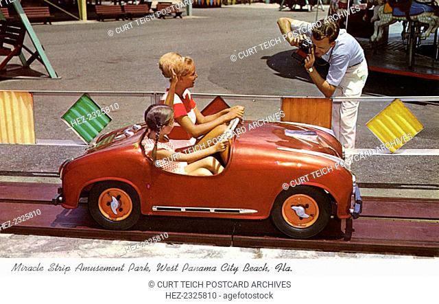 'Miracle Strip Amusement Park, West Panama City Beach, Florida', USA, 1967. A woman and girl riding in a car on a hot rod amusement ride