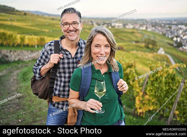 Happy mature couple enjoying wine tasting in vineyard