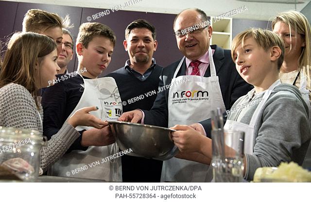 Christian Schmidt (CSU), Minister of Food and Agriculture and TV cook Tim Maelzer (C) cook with pupils of the Schule Eins school in Berlin, Germany