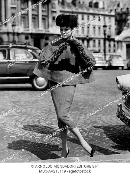 A woman wearing Lanvin Castillo's clothes. A woman wearing skirt and cape, an ushanka and gloves of the French stylist Lanvin Castillo.1956