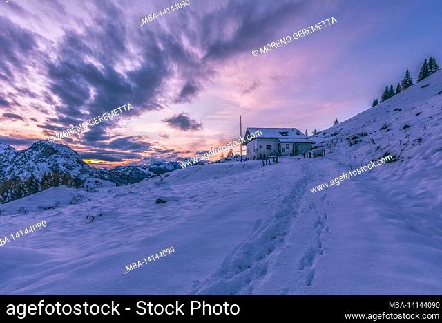 rifugio citta–€  di fiume, italian alpine hut in fiorentina valley at sunset in winter, borca di cadore, belluno, veneto, italy