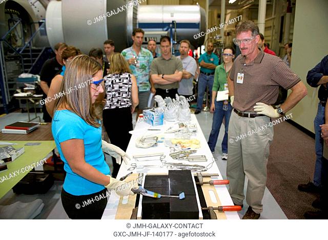 NASA engineer Dana Weigel (foreground) and astronaut Joe Tanner (right) join other astronauts and engineers at the Johnson Space Center to practice techniques...