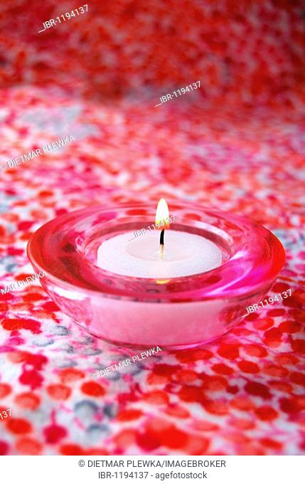 Pink tea candle in pink glass tea light holder