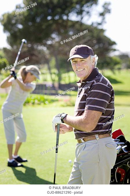 Mature couple playing golf
