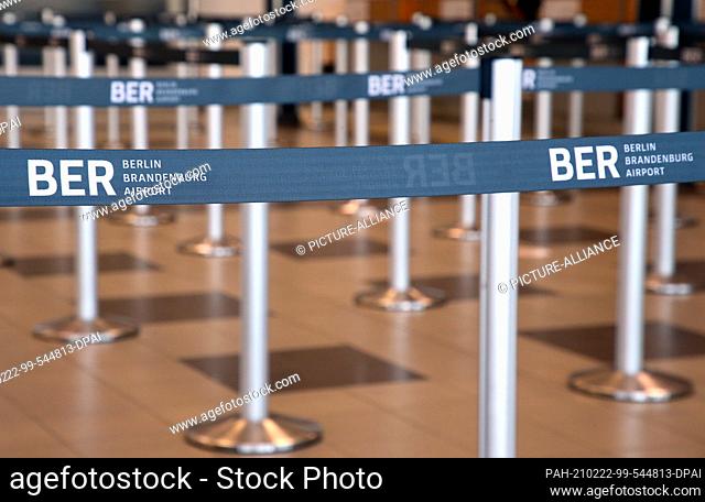 22 February 2021, Brandenburg, Schönefeld: Barrier tapes stand in front of the check-in counters on what is provisionally the last day of operations in the...