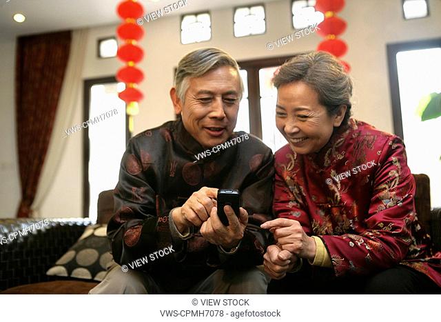 Chinese mature couple making a phone call
