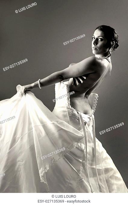 Beautiful bride dressing isolated in a dark background